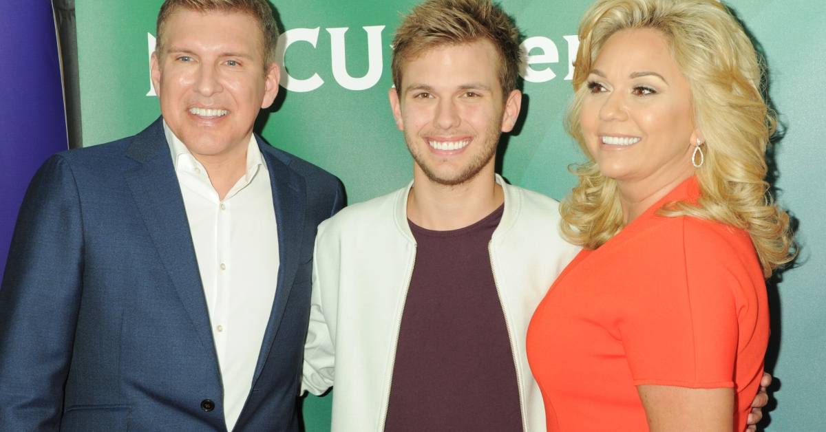 Todd, Chase e Julie Chrisley sorrindo no tapete vermelho para NBC Universal Summer Press Tour