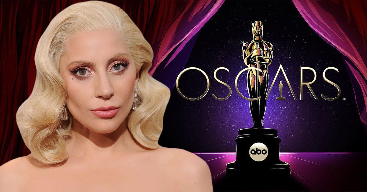 Lady Gaga parecendo surpresa com ombros nus e um clássico penteado loiro, atrás dela está o prêmio do Oscar e o logotipo da ABC