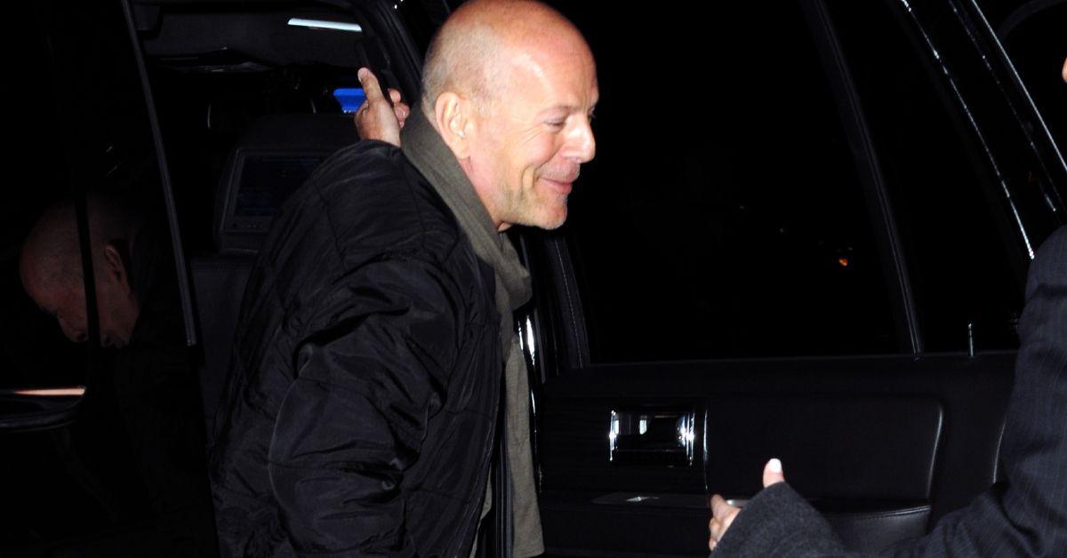 Bruce Willis sorrindo do lado de fora