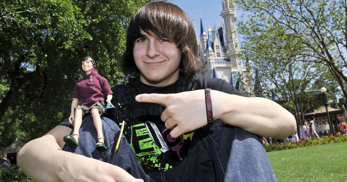 Mitchel Musso posa com uma versão em miniatura de si mesmo, uma figura de ação de seu personagem Hannah Montana, na Disneyworld