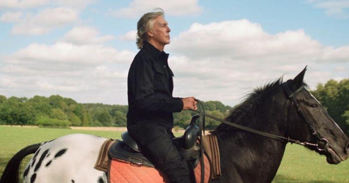 Paul McCartney sentado em um cavalo