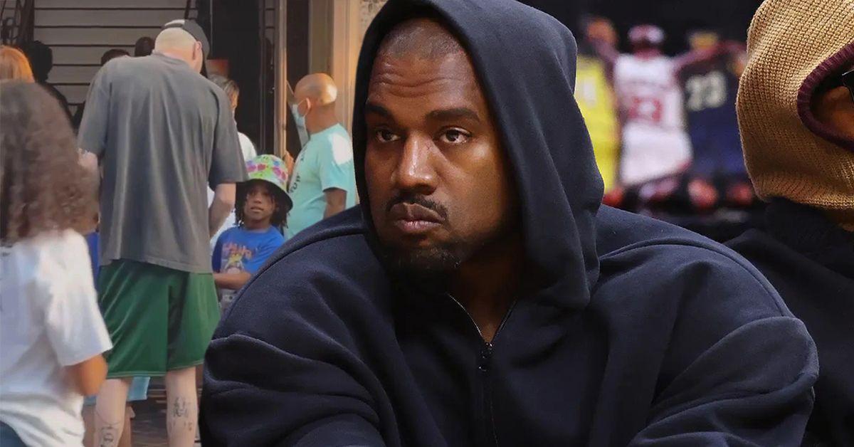 Kanye West na quadra de um jogo de basquete parecendo severo