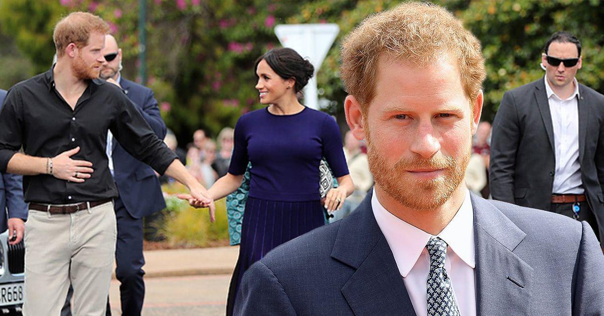 Príncipe Harry andando segurando a mão de Meghan Markle com seguranças ao seu redor (atrás), Príncipe Harry em um terno azul-marinho e o sol em seu rosto (frente)