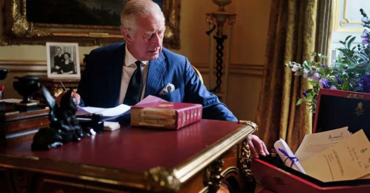 Rei Charles III retratado no escritório com a caixa vermelha