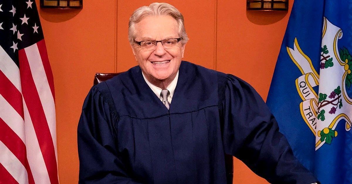 Jerry Springer em vestido azul de juiz