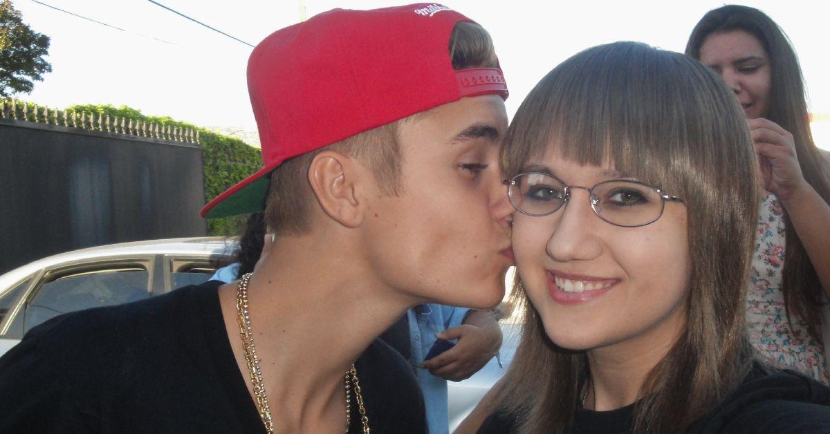Justin Bieber beijando a bochecha de alguém